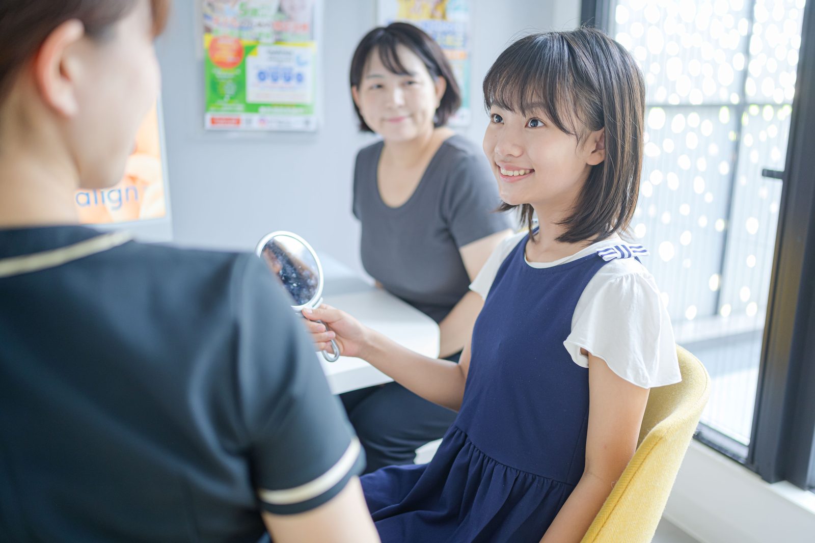 手鏡を使って保護者と子どもに口の中を説明する様子