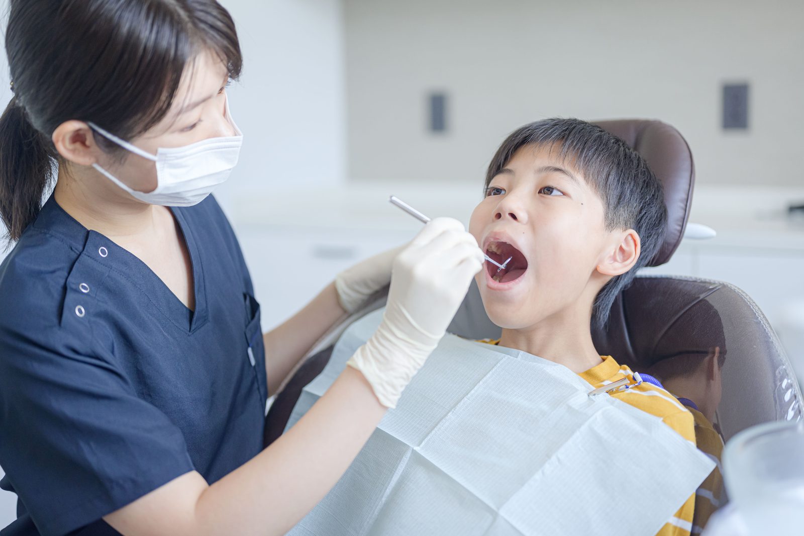 子どもの口の中を確認する歯科衛生士