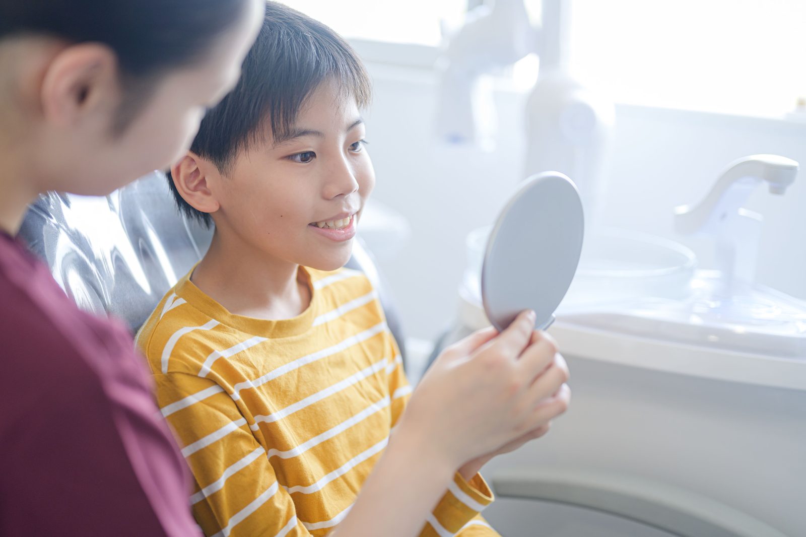 手鏡で自分の歯を確認する子ども